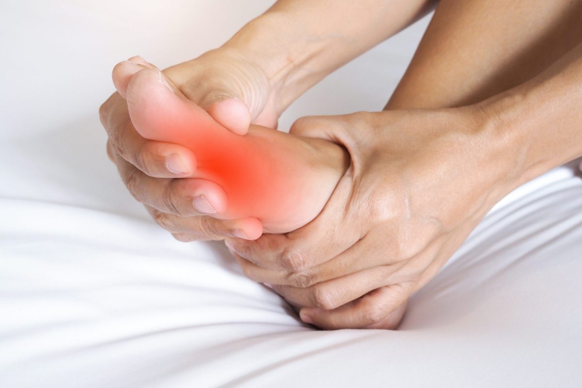 Asian people suffering from severe foot pain. hands reflexology massage pressure points on feet to relieve pain.